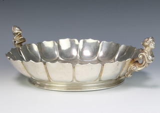 A silver scalloped dish with figural handles London 1928, maker William Comyns & Sons Ltd 958 grams, 33cm