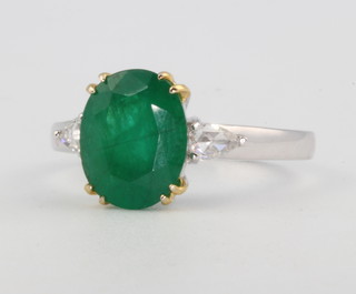 An 18ct white gold oval cut emerald and diamond ring, with yellow gold claws, the centre stone 2.61ct size M 1/2  