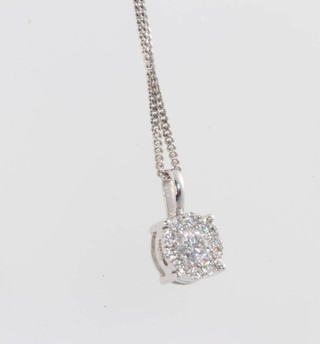 An 18ct white gold diamond pendant, 0.34ct, on a do. chain 