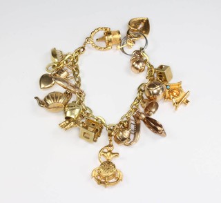 A gilt charm bracelet with 8 9ct gold charms and a quantity of 800 gilt charms