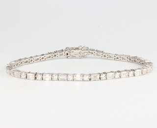 An 18ct yellow and white gold diamond bracelet set with baguette and brilliant cut stones, 5.86ct, 18cm