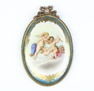 A 19th Century Sevres style oval plaque decorated with angels in a gilt frame with ribbon crest 10cm 