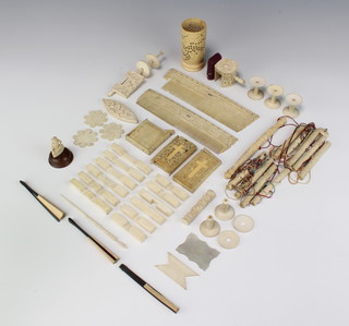 A 19th Century Cantonese carved ivory cotton winder decorated with figures in garden landscapes, minor carved ivory and bone sewing implements