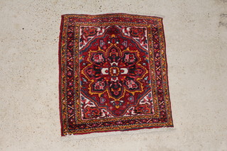 A red and white ground Persian Heriz rug with central medallion 97cm x 48cm 