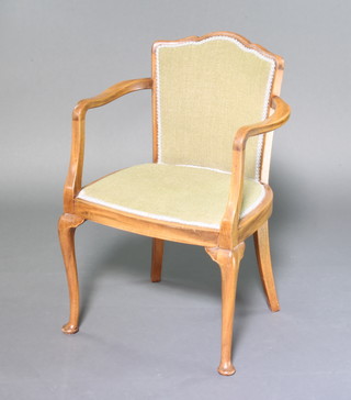 A Queen Anne style beech open arm chair, the seat and back upholstered in green material raised on cabriole supports