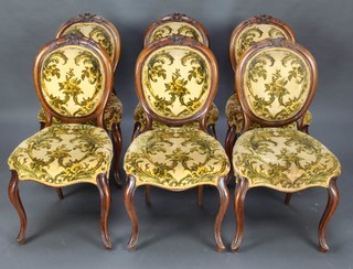 A set of 6 Victorian carved walnut balloon back dining chairs with upholstered seats and backs, the seats of serpentine outline, raised on cabriole supports
