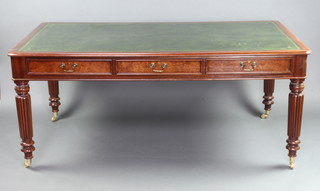 A Georgian style mahogany library table with green inset writing surface above 6 long drawers, raised on turned and reeded supports ending in brass caps and casters 77cm h x 182cm l x 107cm w 