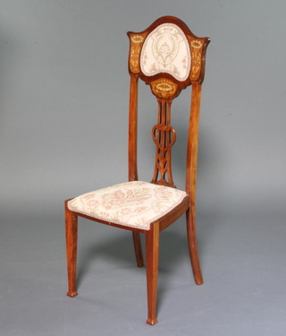 An Edwardian Liberty style inlaid mahogany bedroom chair with pierced vase shaped slat back and upholstered drop in seat raised on square tapered supports 