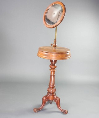 A Victorian circular mahogany shaving stand, the top with an adjustable mirror, the base fitted 2 lidded compartments raised on a turned and fluted column with tripod base 142cm h x 42cm diam. 