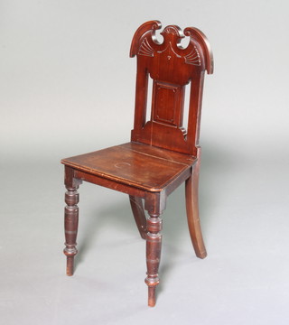 A Victorian mahogany hall chair with shaped back and solid seat, raised on turned supports 