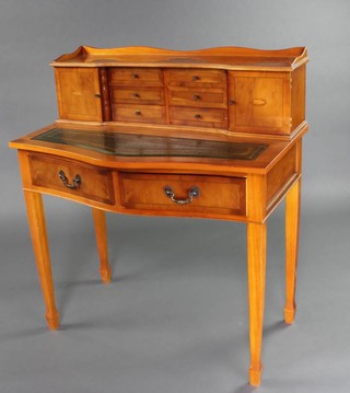 A Georgian stye yew writing table, the raised super structure to the back with 3/4 gallery fitted 6 short drawers flanked by a pair of cupboards with green inset writing surface above 2 long drawers, raised on square tapered supports with spade feet 102cm h x 91cm w x 55cm d 