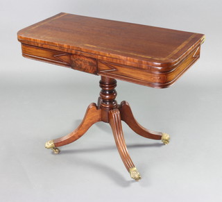 A Regency D shaped card table the top inlaid walnut, raised on a turned column and tripod base ending in brass caps and casters 71cm h x 92cm x 45cm 