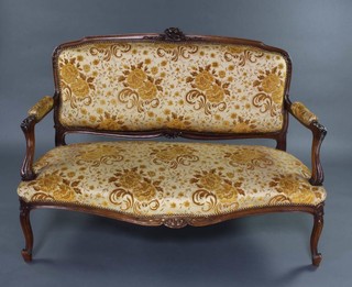 A French carved oak show frame salon settee with crest carved roses, upholstered in yellow sculptured material, raised on cabriole supports 95cm h x 128cm w x 55cm d 