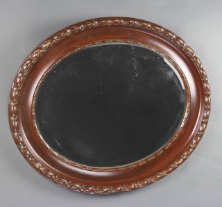 An Edwardian oval bevelled plate wall mirror contained in a carved mahogany frame 65cm x 55cm 