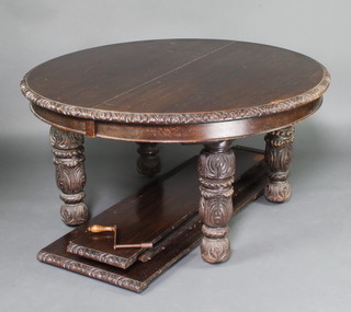 A Victorian carved oak extending dining table with carved apron, raised on 4 carved and turned supports, with 3 extra leaves and complete with winder, 72cm h x 135cm w x 137cm l when closed x 250cm l when extended