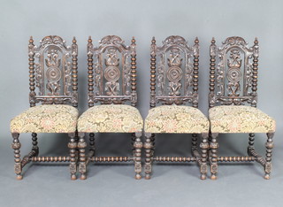A set of 4 Victorian carved and pierced oak Carolean style dining chairs with pierced backs and upholstered seats, raised on turned supports with H framed stretchers 