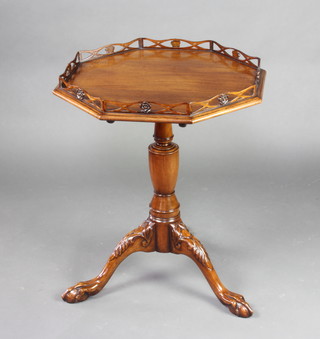 A Chippendale style octagonal mahogany wine table with galleried top, raised on a turned column and tripod base ending in egg and claw feet 72cm h x 59cm w x 58cm d 