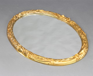 An oval plate wall mirror contained in a decorative gilt frame 78cm x 92cm 