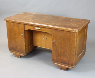 An Art Deco French oak desk fitted a drawer, the kneehole fitted a cupboard enclosed by panelled doors flanked by a pair of pedestals enclosed by panelled doors 76cm h x 144cm w x 55cm d (in one section) 