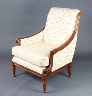 A Wesley-Barrell, a mahogany show frame armchair  upholstered in cream and golf leaf print material,  raised on turned reeded supports 