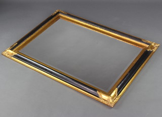 A rectangular bevelled plate wall mirror contained in a gilt and black painted frame 112cm x 80cm 