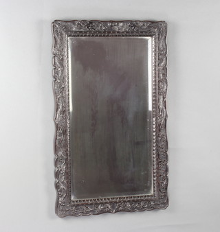 A rectangular bevelled plate mirror contained in a Chinese carved hardwood frame decorated dragons 71cm x 44cm 