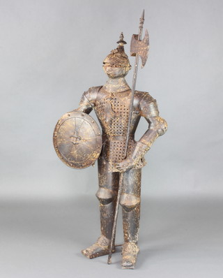 A pressed metal model of a standing knight with shield and halberd 140cm h x 59cm w 23cm d 