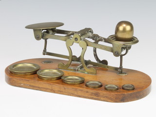 Ratcliffe, a pair of 19th Century  brass letter scales raised on an oval oak base complete with weights 