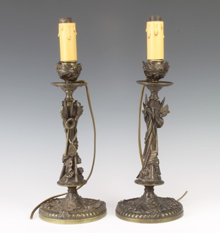 A pair of 19th Century bronze candlesticks with detachable sconces, converted for electricity decorated military trophies 30cm x 13cm 