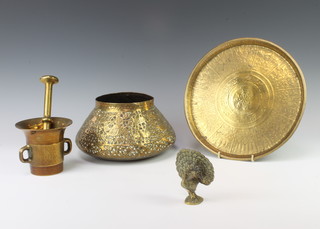 A circular Eastern brass frame engraved charger 27cm, an embossed brass vase decorated figures and animals 13cm, a brass mortar and pestle 10cm x 11cm, a brass figure of a peacock 9cm x 7cm x 3cm  
