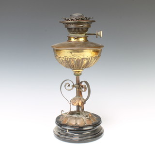 A 19th Century copper and brass oil lamp reservoir supported by 3 scroll supports and with Hinks no.2 deluxe burner, raised on a ceramic base 39cm h x 17cm 