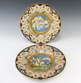 A pair of Italian Majolica plates decorated with classical figures enclosed amongst mythical figures and birds 32cm 
