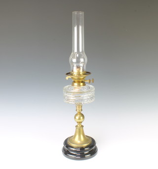A Victorian panelled glass oil lamp reservoir raised on a gilt metal column with ceramic socle base complete with clear glass chimney 64cm x 15cm 