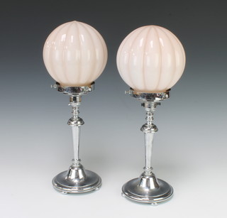 A pair of Art Deco chrome table lamps with opaque pink glass shades