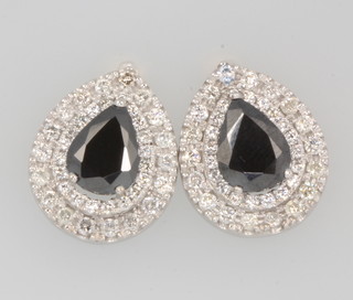 A pair of 18ct white gold pear shaped black diamond cluster ear studs, the centre stones approx 7.0ct, the brilliant cut diamonds 2.27ct, with GLI certificate 