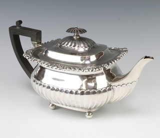 An Edwardian silver teapot with scroll rim and demi-fluted decoration with ebony mounts London 1907 maker William Hutton & Sons gross 714 grams 