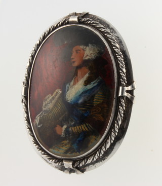A silver brooch with portrait study 
