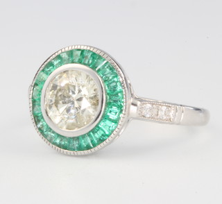 A 14ct white gold Art Deco style diamond and emerald ring, the centre stone approx. 1.12ct surrounded by tapered baguette cut emeralds 0.56ct and diamond shoulders 0.06ct size M 1/2