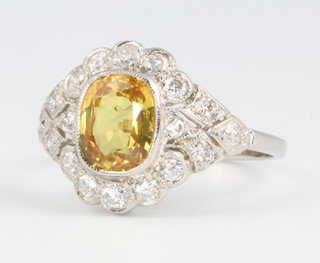 An 18ct white gold yellow sapphire and diamond cluster ring, the centre stone approx. 2ct surrounded by brilliant cut diamonds approx. 0.65ct size N 1/2