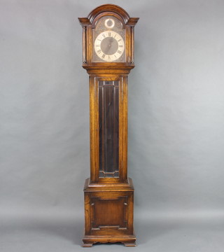 A 1930's chiming longcase clock, the 25cm arched gilt dial with silvered chapter ring, Roman numerals and gilt metal spandrels, having a strike indicator, contained in an oak case with sliding hood 198cm h 
