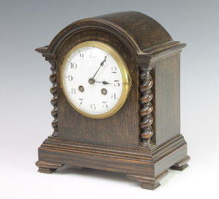 A 1930's French striking mantel clock with enamelled dial and Roman numerals contained in an oak arch shaped case (no key)
