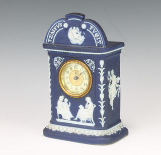 A mantel timepiece with enamelled dial and Arabic numerals contained in a Wedgwood style blue Jasperware case marked Tempus Fujit 