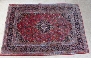 A red and blue ground Persian Kashan carpet with central medallion within multi-row borders 338cm x 230cm 
