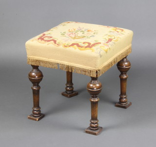 A Jacobean style square walnut stool with Berlin woolwork seat, raised on cup and cover supports 44cm h x 42cm w x 42cm d 