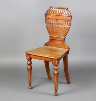 A Georgian oak hall chair, the back in the form of a lidded urn with solid seat raised on turned and fluted supports 