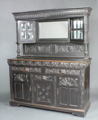 A Victorian carved ebonised oak sideboard with raised mirrored back fitted a pair of cupboards enclosed by glazed panelled doors above a recess, the base fitted 2 long drawers and triple cupboards with lion mask handles 185cm h x 150cm w x 54cm d 