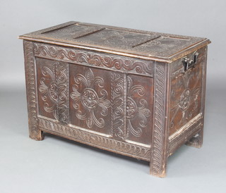 An 18th Century carved oak coffer of panelled construction with hinged lid and iron handles to the sides 70cm x 97cm x 52cm 