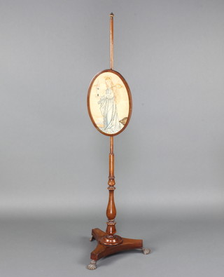 A Victorian mahogany pole screen the oval Berlin woolwork banner decorated a standing Virgin Mary, raised on a turned column and tripod base with gilt hoof feet 143cm h x 34cm w   