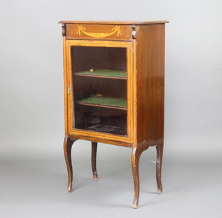 An Edwardian inlaid mahogany music cabinet with cross banded top, the apron inlaid swags, the shelved interior enclosed by a glazed panelled door raised on shaped supports 106cm h x 57cm w x 34cm d 