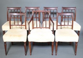 A set of 6 Georgian mahogany stick and bar back dining chairs with over stuffed seats, raised on turned supports together with a similar carver chair (old repair to the back and arm) 